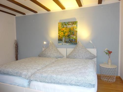 een slaapkamer met een bed en een schilderij aan de muur bij Eifelheimat-Lorbach in Schleiden-Herhahn in Schleiden