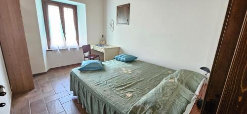 a bedroom with a bed and a desk and a window at B&B La Fonte in Staffolo