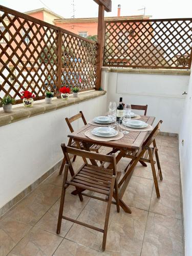 a wooden table and chairs on a balcony at La Casetta tra Alghero e Stintino in Palmadula