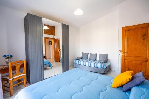 een slaapkamer met een groot blauw bed en een spiegel bij Il Tiglio-Holiday Home in Massa Lubrense