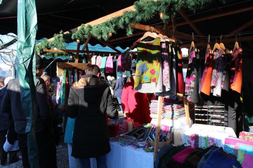 a group of people standing around a market with clothes at Ferienwohungen Familie Schröttle in Sonthofen
