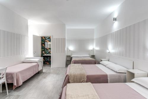 a room with three beds and a mirror at AltaDomus Roma in Rome