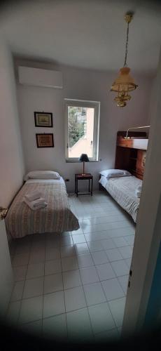 1 dormitorio con 2 camas y ventana en Belview Positano en Positano