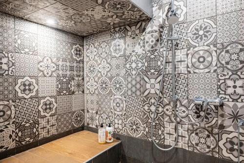 a bathroom with black and white tiles on the wall at Entre Aix et Marseille in Rognac