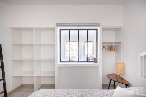 a bedroom with white shelves and a window at Entre Aix et Marseille in Rognac