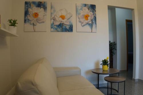 a living room with a couch and two paintings on the wall at Casa Vacanze Podere San Giusto Volterra in Volterra