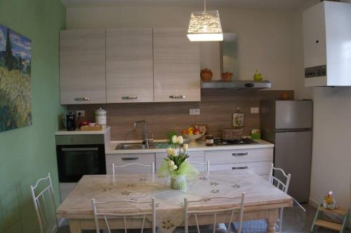 a kitchen with a table with chairs and a sink at Casa Vacanze Podere San Giusto Volterra in Volterra