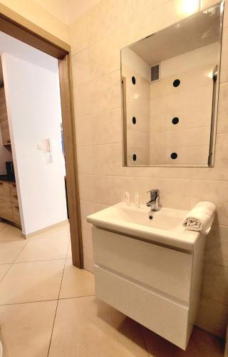 a white bathroom with a sink and a mirror at Apartament PrzyLesie Jantar by TriApart in Jantar