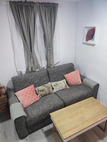 a living room with a gray couch with pillows at Apartamento Gitanilla in Chipiona