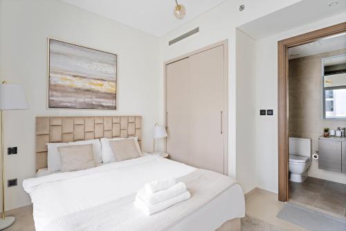 a white bedroom with a bed and a toilet at Beautiful 2 bedroom next to Business Bay - Sobha Creek Vista in Dubai