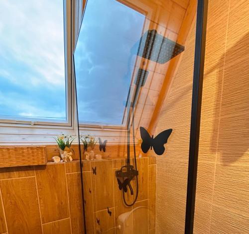 a room with a window with butterflies on the wall at Cabana Ana Barsana in Bîrsana