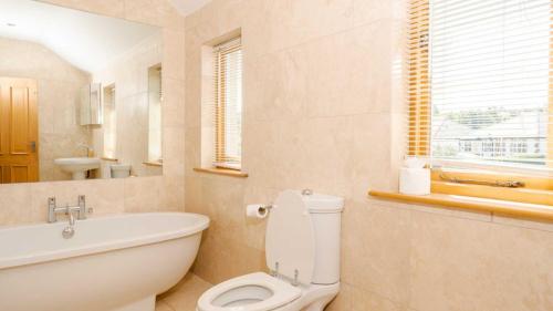 een badkamer met een toilet, een bad en een wastafel bij Roslyn in Bakewell