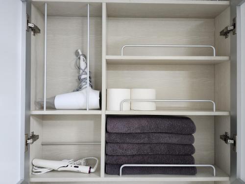 a closet with white shelves and towels in it at Sokcho Summitbay 1701 "Ocean View" in Sokcho