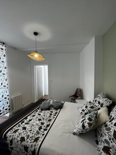 una camera da letto con un letto grande con cuscini sopra di La maison castelpontine T3 a Pont-du-Château