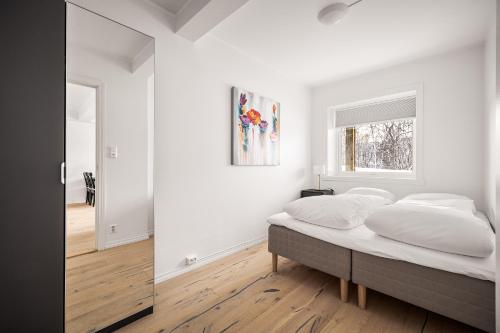 a white bedroom with a bed and a window at Gullstein in Geilo