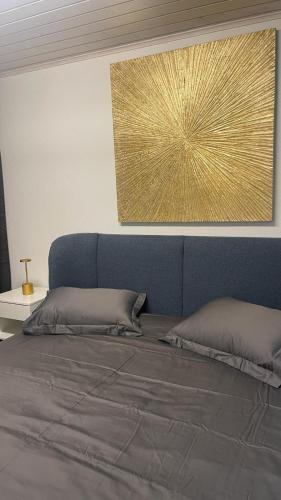 1 dormitorio con 1 cama grande y una pintura dorada en La Croisette SA en Ginebra