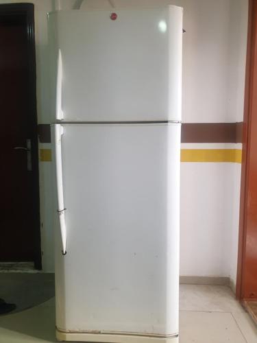 a white refrigerator is sitting in a room at Sahara Hostel and Private rooms in Dubai