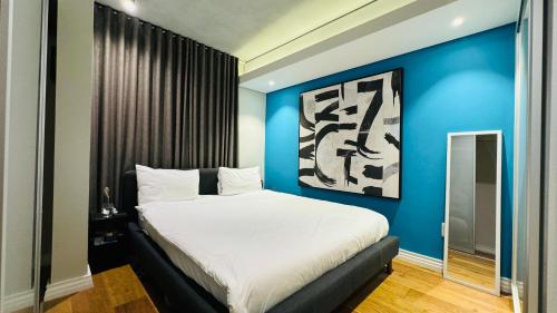 Un dormitorio con una cama grande con una pared azul. en Sunny Apartment with Pool&Terrace at The Docklands, en Ciudad del Cabo