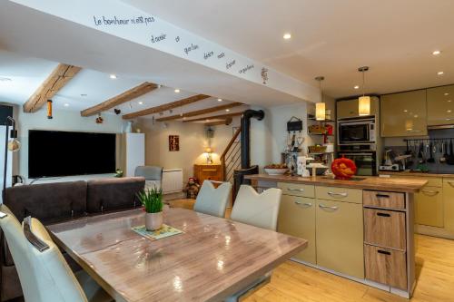 Il dispose d'une cuisine et d'un salon avec une table et des chaises en bois. dans l'établissement Maison village proche lac d'annecy, à Faverges