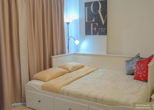 - une chambre avec un lit blanc et une lampe dans l'établissement Rooms hua hin nearby the beach, à Hua Hin