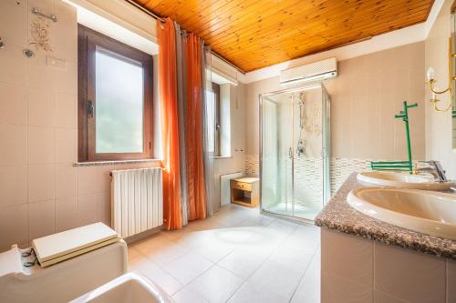 uma casa de banho com um lavatório, um WC e uma janela. em Villa bifamiliare con giardino em Teulada