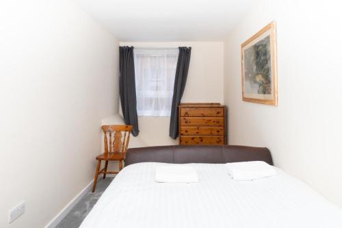 1 dormitorio con 1 cama, 1 silla y 1 ventana en Brilliantly Located 2BD Flat Heart of Edinburgh! en Edimburgo