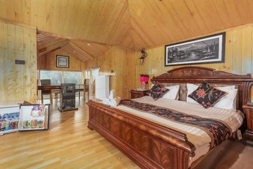 a bedroom with a large wooden bed in a room at Marina Drung Waterfall By Stay Pattern in Gulmarg