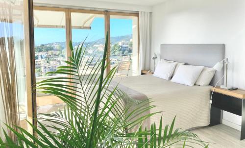 um quarto com uma cama e uma grande janela em Hotel Apartment with Breathtaking Panoramic Sea and Mountain Views em Palma de Maiorca