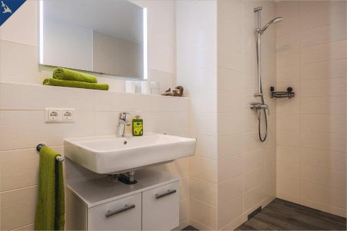 La salle de bains est pourvue d'un lavabo et d'une douche. dans l'établissement An der Haffküste Otterhöhle, à Zirchow