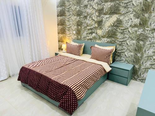 a bedroom with a bed with two pillows at Sall Residence Mbour Saly in Mbour