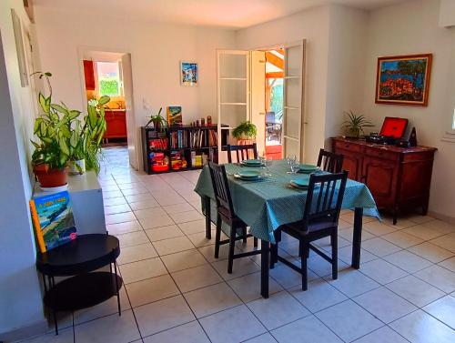 une salle à manger avec une table et des chaises bleues dans l'établissement Jolie maison à 800m de la plage, à Hermanville-sur-Mer