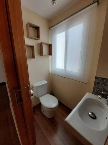 a bathroom with a toilet and a sink and a window at Apartamento Blanes playa (Costa Brava) in Blanes