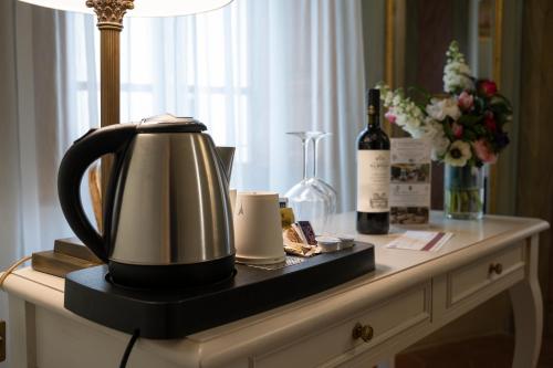 a tea kettle and a bottle of wine on a table at Hotel Palazzo San Niccolò & Spa in Radda in Chianti