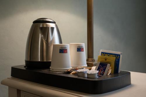 a counter with a coffee maker and two cups on it at Hotel Palazzo San Niccolò & Spa in Radda in Chianti