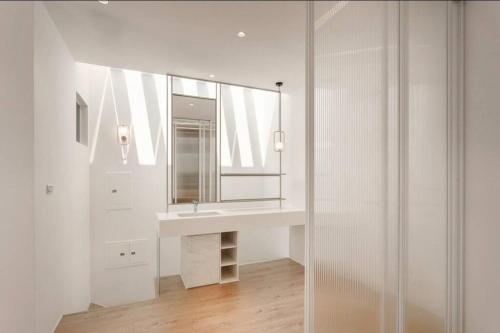 a white bathroom with a sink and a mirror at 里白民宿 in Ho-mu