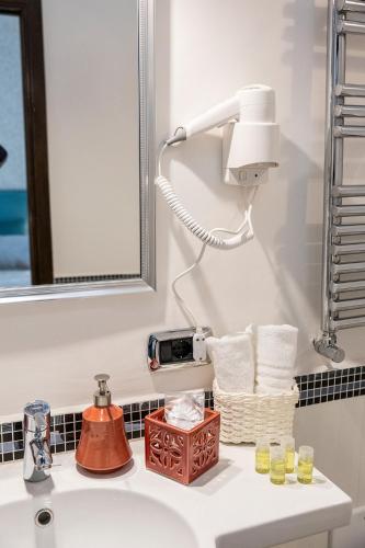 a bathroom with a sink with a mirror and a light at B & B Boutique Epoca in Salerno