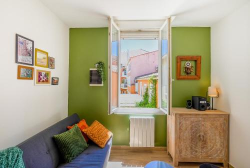 un salon avec un canapé et une fenêtre dans l'établissement Verde y Terracotta, T2, Centre-ville, Figuerolles, à Montpellier