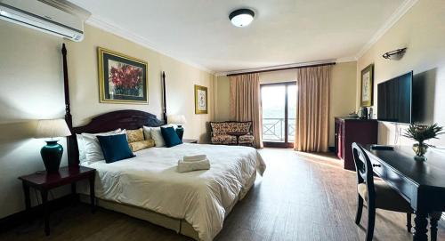 a hotel room with a bed and a desk and a desk at Far Hills Country Hotel in George