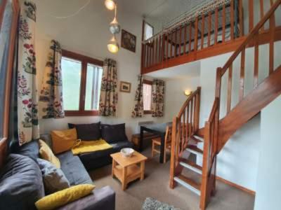 - un salon avec un canapé et un escalier dans l'établissement Duplex plein sud pieds des pistes, à Tignes