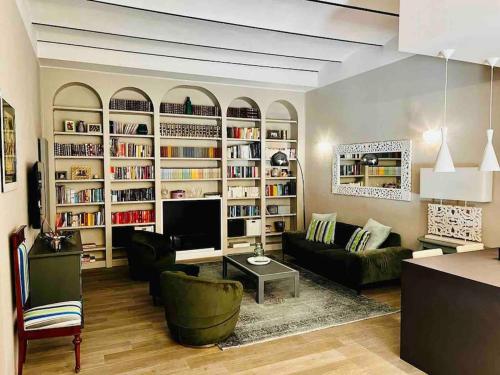 ein Wohnzimmer mit einem Sofa, einem TV und Büchern in der Unterkunft Nel cuore di Bologna in Bologna