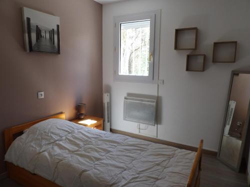 une chambre avec un lit et une fenêtre dans l'établissement St Cyprien villa de charme avec piscine, à Saint-Cyprien