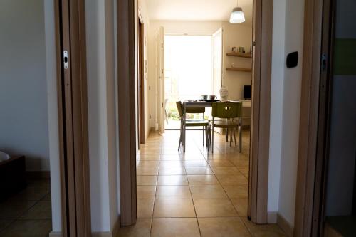 a hallway with a table and a dining room at Petite Maison in Marzamemi