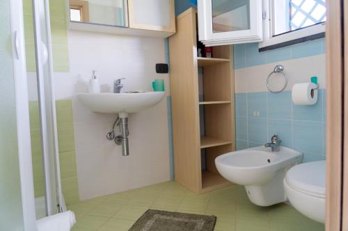 a bathroom with a sink and a toilet at Petite Maison in Marzamemi