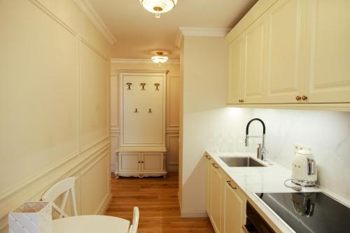 a kitchen with white cabinets and a sink at Boutique Apartments Kempes in Liepāja
