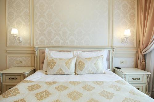 sypialnia z łóżkiem z poduszkami i dwoma stołami w obiekcie Boutique Apartments Kempes w mieście Lipawa