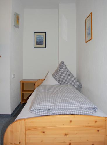 a bed in a bedroom with a wooden frame at Gästehaus Familie Gebhard Schädle in Grän