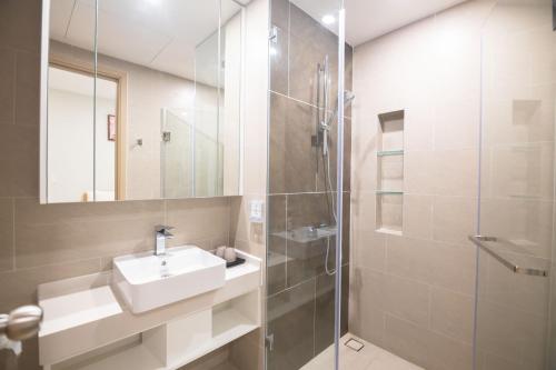a bathroom with a sink and a glass shower at Căn Hộ Ban Công Hướng Biển - FREE HỒ BƠI VÔ CỰC, SAUNA, GYM, KARAOKE, BBQ - The Sóng Vũng Tàu ! in Vung Tau