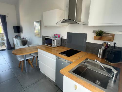 een keuken met een wastafel en een houten aanrecht bij Plage à 400 m Studio tout confort Terrasse Clim Parking in Hyères