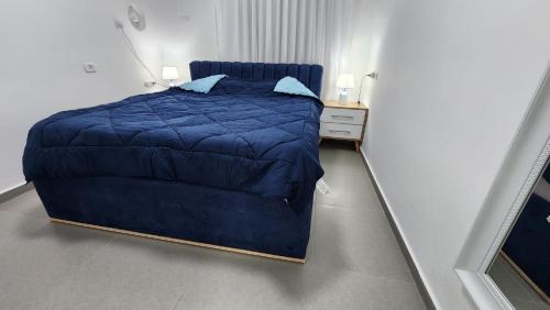 a small bedroom with a blue bed and a nightstand at Haifa night's in Haifa