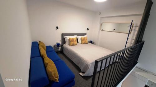 - une chambre avec un lit et un canapé bleu dans l'établissement KaunasInn Loft, à Kaunas